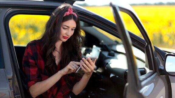 可爱的女孩在车里用智能手机上网