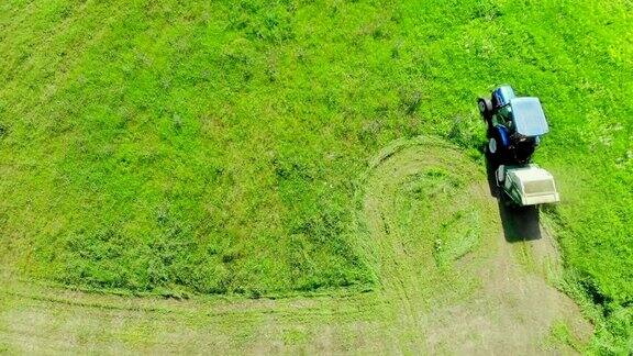 空中俯瞰现代拖拉机在农田割草