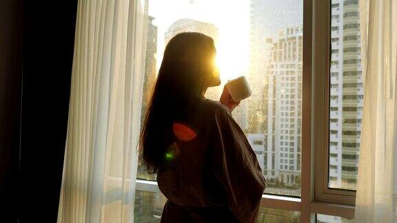 在窗边喝着美味咖啡的女士剪影