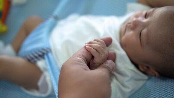 男婴握着父亲的食指