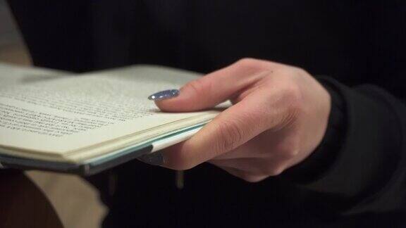 一个女人的手拿着一本打开的书