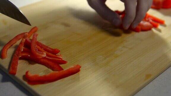 把红甜椒切成薄片放在木板上煮熟