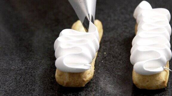 糕点师将奶油涂在美味的泡芙上