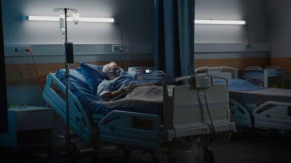 医院病房:新冠肺炎、疾病、疾病、手术后戴着氧气面罩躺在床上努力恢复的老人肖像为生命而战的老人深蓝色悲伤镜头
