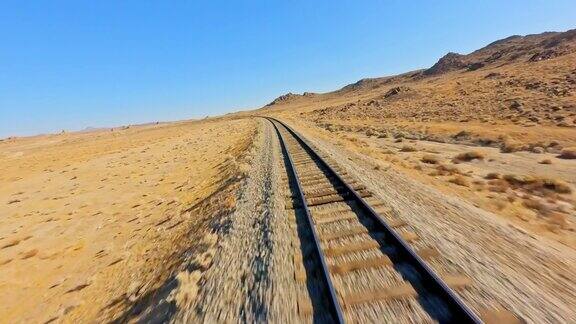 FPV无人机拍摄的沙漠火车轨道在美国莫哈韦沙漠的特罗纳尖峰石阵附近