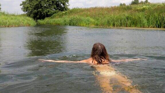 运动穿着白色比基尼的苗条年轻女子开始在湖中游泳