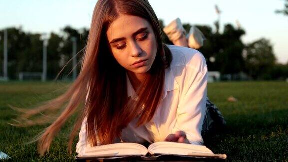 一位美丽的年轻女子正在公园里看书一个学生和一个女学生