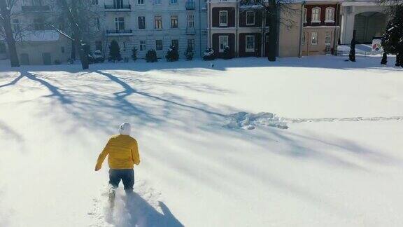 一个男人在厚厚的雪地上奔跑的鸟瞰图