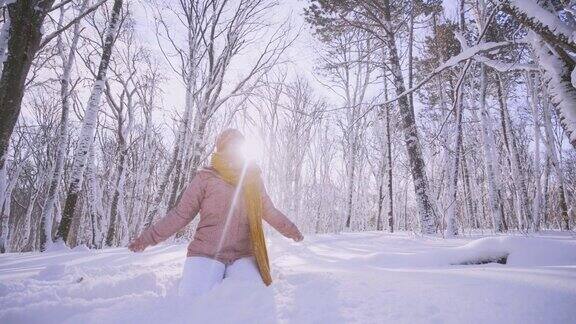 快乐的女人在冬天的森林里玩耍