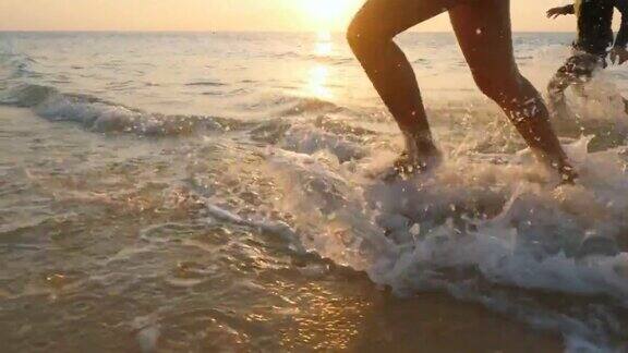 美丽的女人在日落时在海滩上散步和跑步