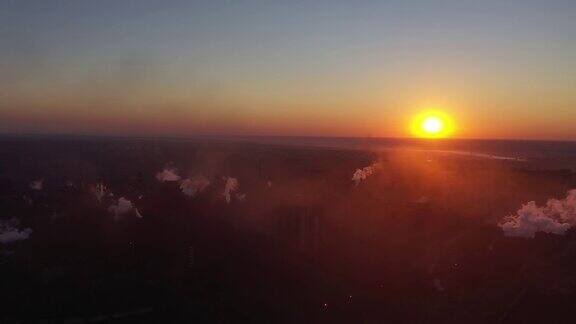黎明时分在太阳的映衬下冶金厂的烟雾和煤烟