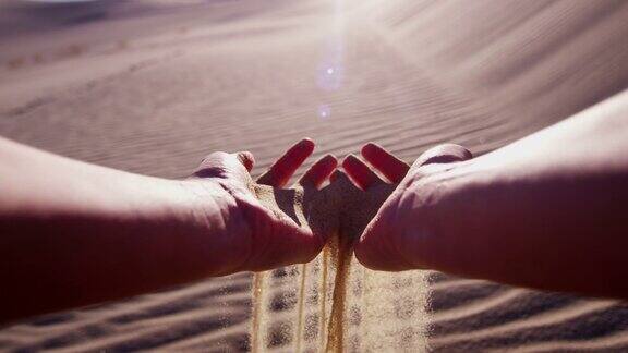 在干旱的环境中女孩们手握沙漠中的沙子