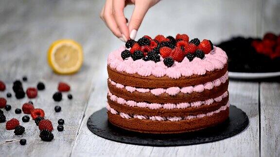 糕点师用浆果装饰蛋糕