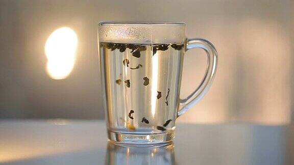 用透明玻璃杯将热水倒在茶上