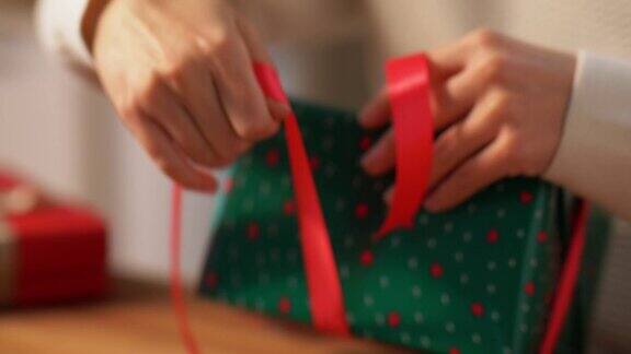 双手包装圣诞礼物和系蝴蝶结