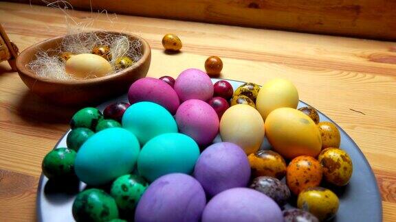 木桌上灰色的盘子里放着五颜六色的复活节彩蛋