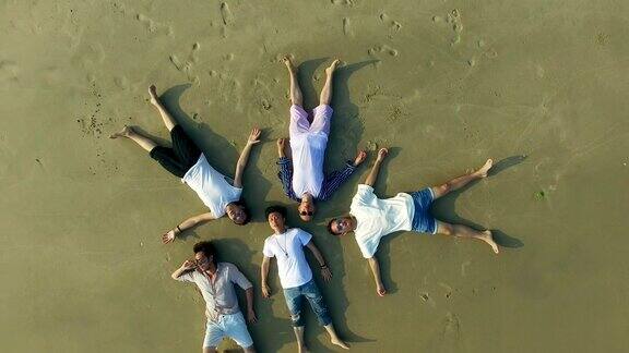 年轻的亚洲成年人躺在沙滩上眼睛闭着