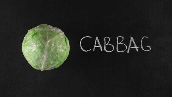 定格动画与绿色卷心菜和手写文字在黑色黑板上俯视图素食或蔬菜广告