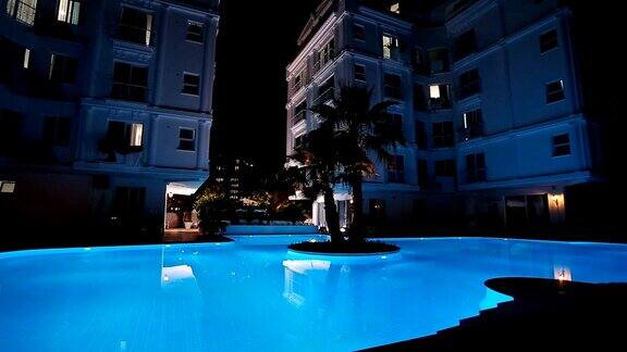 游泳池和瀑布在土耳其的夜间度假背景