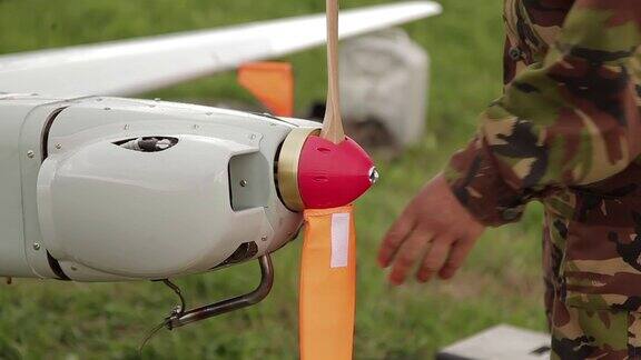 人从商用空中侦察或军用飞机的螺旋桨上取下盖子军用工程师为军用飞行作业准备无人驾驶飞行器