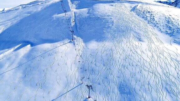 航拍积雪覆盖的山上移动着的滑雪缆车
