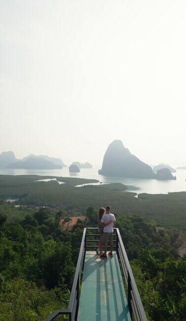 垂直视频鸟瞰图夫妇在桥上观景塔欣赏亚洲海滩海景