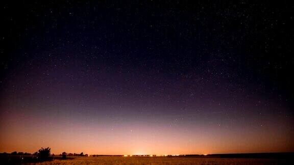 自然之夜夏日草地上的星空发光的星星和日落日出的灯光之上的景观