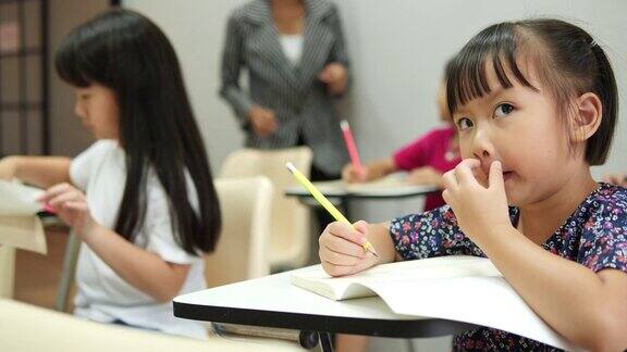 亚洲的孩子们在学校的教室里一起学习和写作教育