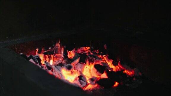 美丽的红火由切片的木头深灰色的黑色煤内的金属火盆木头在火盆里燃烧着明亮的黄色火焰火苗为烧烤做饭做准备火盆烧烤4k