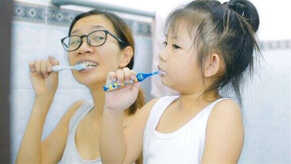 亚裔母亲和女儿一起在浴室刷牙