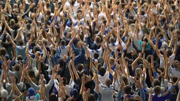 观众举起双手支持足球队等待比分