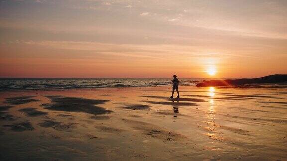 日落时分走在海边的女人