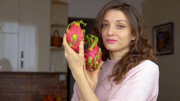 小女孩手里拿着两颗新鲜成熟的有机火龙果异国的水果健康的饮食理念