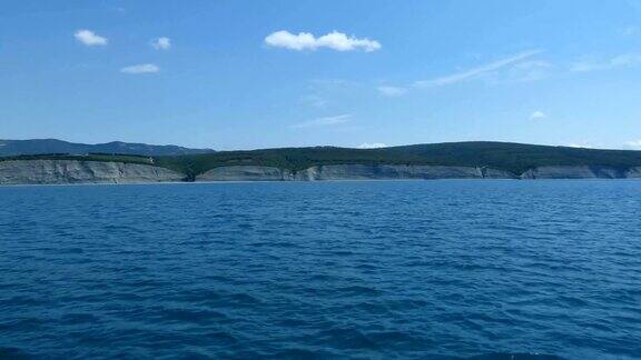 从海岸边的船上观看蓝色的水小海滩灰色的岩石