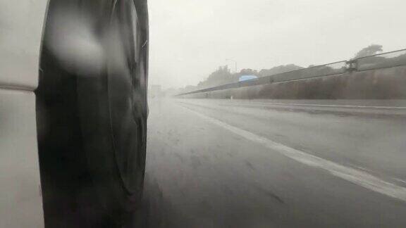 在高速公路上一辆红色小汽车在大雨中超过了我汽车轮胎和飞溅的水