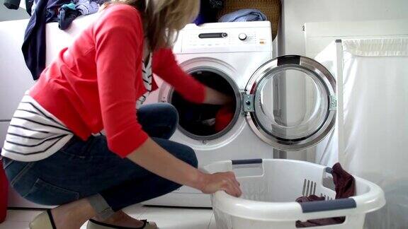 把衣服放进洗衣机的女人