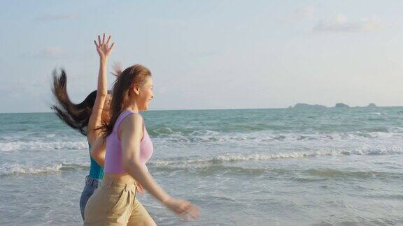 亚洲年轻美丽的女人朋友在夏天的海滩上散步迷人的两个女孩旅行者感到快乐和放松而在热带海岛度假旅行
