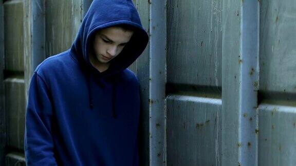 孤独的男孩在学校后院散步无聊的少年逃课