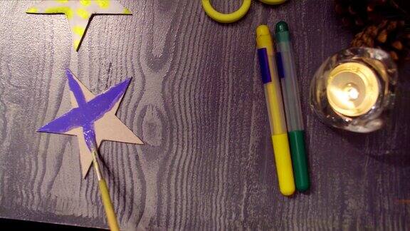 小女孩的手在画一个硬纸板星星