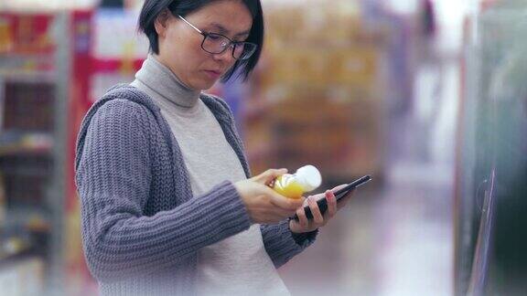 怀孕的亚洲妇女购物在市场看手机