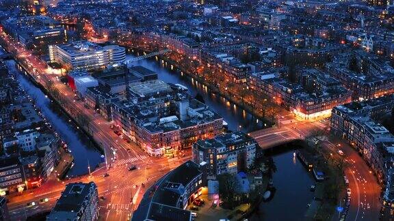无人机拍摄的阿姆斯特丹市中心美丽的夜间鸟瞰图上面有许多狭窄的运河灯火通明的街道和古老的历史房屋