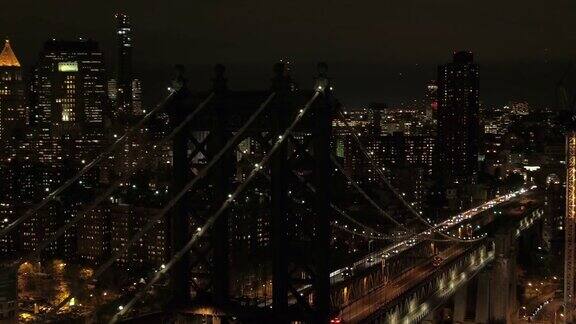 空中特写:夜晚汽车穿过著名的曼哈顿大桥灯光照亮了纽约