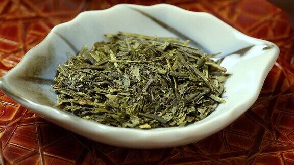 日本绿茶干叶放在小盘子里