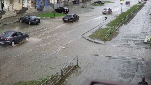 汽车在雨中行驶在被洪水淹没的道路上慢镜头