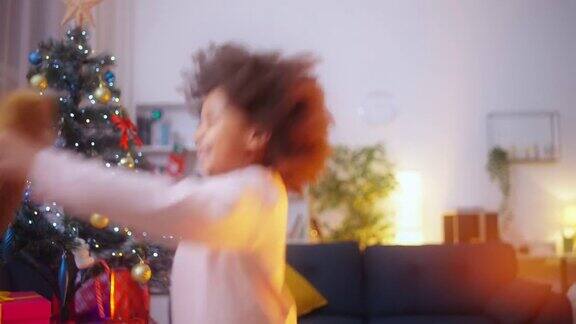 兴奋的黑人女孩拿着泰迪熊玩具跳舞拿着圣诞礼物感到很开心