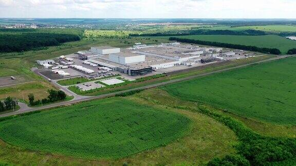 被绿色自然环绕的巨大工业厂房夏日田野间的现代农业工厂综合体鸟瞰图
