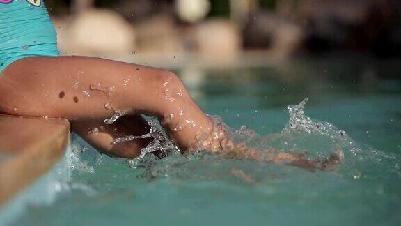 婴儿的脚在游泳池溅水的特写