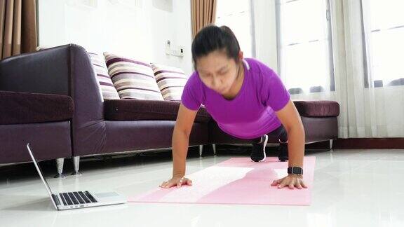 亚洲女性在家里做俯卧撑锻炼