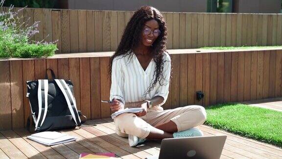 年轻快乐的黑人女学生在户外学习虚拟在线研讨班