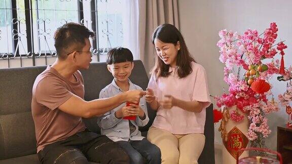 春节期间一个亚洲小孩在客厅里接受父母的春节红包